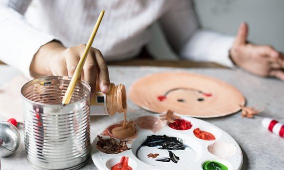 Ett barn som häller färg i en palett.