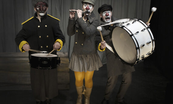 123 SCHTUNK - Ett drömspel (dekorativ bild på tre av skådespelarna som clowner med musikinstrument mot en mörk bakgrund)